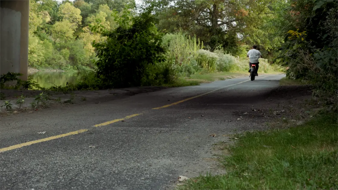 rider using a cheap ebike on a long road