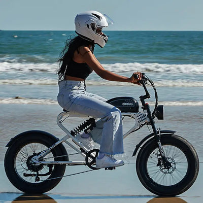 A woman wearing a helmet riding a Meelod DK300PLUS along the coast